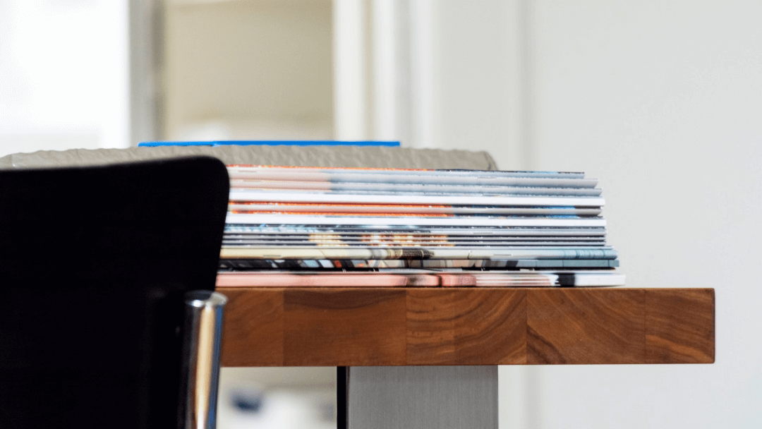 A selection of JinkoSolar brochures piled on a wooden desk