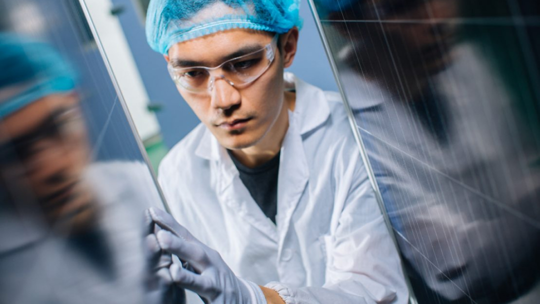 A JinkoSolar technician inspects a PV module